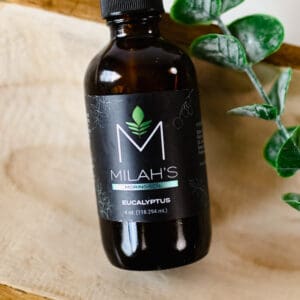 A bottle of milah 's cbd oil sitting on top of a wooden board.